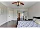 Spacious bedroom with a ceiling fan, hardwood floors, and an attached dressing room at 7470 Oldbury Pl, Cumming, GA 30040