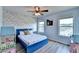 Bright bedroom featuring a blue bed, wood-look flooring, and decorative cloud wallpaper at 7470 Oldbury Pl, Cumming, GA 30040
