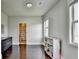Bright bedroom with hardwood floors, natural light, and storage shelves at 7470 Oldbury Pl, Cumming, GA 30040