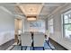 Elegant dining room featuring coffered ceilings, modern chandelier, wainscoting, and natural light at 7470 Oldbury Pl, Cumming, GA 30040