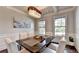 Bright dining area with wainscoting, a modern chandelier, and large windows, perfect for Gathering gatherings at 7470 Oldbury Pl, Cumming, GA 30040