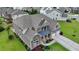 Beautiful home with stone accents, a covered porch, three-car garage, and professionally landscaped yard at 7470 Oldbury Pl, Cumming, GA 30040