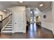 Spacious foyer with hardwood floors, staircase, and view to the entry door and open floor plan at 7470 Oldbury Pl, Cumming, GA 30040