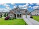 Charming two-story home with a well-manicured lawn, beautiful landscaping, and a three car garage at 7470 Oldbury Pl, Cumming, GA 30040