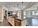 Open kitchen with a large island, stainless steel appliances, hardwood floors, and a view of the living room at 7470 Oldbury Pl, Cumming, GA 30040