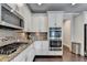 Gourmet kitchen features stainless steel appliances, granite countertops, custom cabinetry, and stylish backsplash at 7470 Oldbury Pl, Cumming, GA 30040