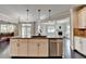 Stylish kitchen with granite island, stainless steel dishwasher and view to the living room and fireplace at 7470 Oldbury Pl, Cumming, GA 30040