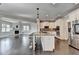 Open kitchen with a large island, white cabinets, stainless steel appliances, and hardwood floors at 7470 Oldbury Pl, Cumming, GA 30040