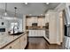 Kitchen with stainless steel appliances, white cabinetry, granite countertops, and hardwood floors at 7470 Oldbury Pl, Cumming, GA 30040
