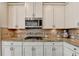Kitchen with granite countertops, stainless steel appliances, a gas cooktop, and white cabinets at 7470 Oldbury Pl, Cumming, GA 30040