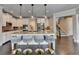 Open-concept kitchen featuring a large island, pendant lighting, stainless steel appliances, and modern bar stools at 7470 Oldbury Pl, Cumming, GA 30040