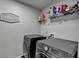 Modern laundry room featuring a sleek washer and dryer set with modern shelves at 7470 Oldbury Pl, Cumming, GA 30040