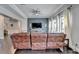 Cozy living room featuring a brown leather couch, dark hardwood floors, and ample space for entertaining at 7470 Oldbury Pl, Cumming, GA 30040