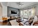 Comfortable living room with a modern TV, decorative rug, ceiling fan, and plenty of natural light at 7470 Oldbury Pl, Cumming, GA 30040