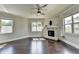 Bright living room with hardwood floors, fireplace, ceiling fan and natural light from multiple windows at 7470 Oldbury Pl, Cumming, GA 30040