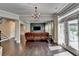 Living room with hardwood floors, a brown leather sofa, a TV, and a staircase at 7470 Oldbury Pl, Cumming, GA 30040