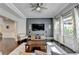 Bright living room with hardwood floors, modern decor, a large TV, and a ceiling fan at 7470 Oldbury Pl, Cumming, GA 30040