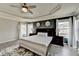 Inviting main bedroom with dark accent wall, tray ceiling, and plush rug at 7470 Oldbury Pl, Cumming, GA 30040