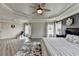 This main bedroom features a tray ceiling, ceiling fan, wood floors and sitting area at 7470 Oldbury Pl, Cumming, GA 30040