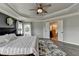 Spacious main bedroom features a tray ceiling, ceiling fan, and ensuite bathroom at 7470 Oldbury Pl, Cumming, GA 30040