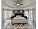 Inviting main bedroom with dark accent wall, tray ceiling, and plush rug at 7470 Oldbury Pl, Cumming, GA 30040