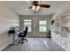 Home office includes built-in shelves, gray rug, and two sunny windows, creating an inspiring and productive workspace at 7470 Oldbury Pl, Cumming, GA 30040