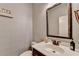 Cozy half bathroom featuring stylish wallpaper, a framed mirror, and bronze fixtures at 7470 Oldbury Pl, Cumming, GA 30040