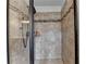 This tiled shower has a glass door and shelving for storage at 7470 Oldbury Pl, Cumming, GA 30040