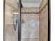 This tiled shower has a glass door and shelving for storage at 7470 Oldbury Pl, Cumming, GA 30040