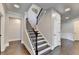 Elegant staircase with dark wood steps, iron railings, and bright white trim at 7470 Oldbury Pl, Cumming, GA 30040