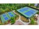 Aerial view of the community tennis courts surrounded by green landscaping and mature trees at 7470 Oldbury Pl, Cumming, GA 30040