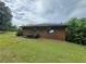 Spacious backyard featuring a well-maintained lawn, a small brick building and a lush green view at 1856 Butler Bridge Rd, Covington, GA 30016