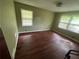Vacant bedroom with hardwood floors, two windows, and off-white walls at 1856 Butler Bridge Rd, Covington, GA 30016