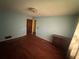 This bedroom features blue walls, a curtained window, and wood floors at 1856 Butler Bridge Rd, Covington, GA 30016