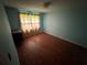 This bedroom features blue walls, a curtained window, and wood floors at 1856 Butler Bridge Rd, Covington, GA 30016