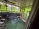 Enclosed sunroom with ceiling fan, chairs, and peaceful backyard views at 1856 Butler Bridge Rd, Covington, GA 30016