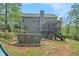 Back exterior of home featuring a screened porch with deck, above ground pool, and wooded lot at 27 Rose Brooke Cir, White, GA 30184