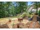 Enjoy this backyard space with a swing set, fire pit, stone pavers, and wood-terraced landscaping at 27 Rose Brooke Cir, White, GA 30184