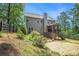 Landscaped backyard featuring mature trees, a privacy fence, and a glimpse of the screened porch at 27 Rose Brooke Cir, White, GA 30184