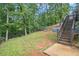 A backyard with a patio, a slide, a trampoline, and some fencing at 27 Rose Brooke Cir, White, GA 30184