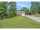 Inviting home showcasing stone accents, gray siding, a sprawling lawn, and mature trees at 27 Rose Brooke Cir, White, GA 30184