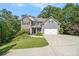 Lovely home with stone details, gray siding, a two-car garage, and a well-kept lawn surrounded by mature trees at 27 Rose Brooke Cir, White, GA 30184