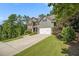 Stylish home with stone details, gray siding, a two-car garage, and a long driveway with mature trees at 27 Rose Brooke Cir, White, GA 30184