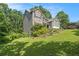 Attractive home with stone accents and gray siding, nestled on a gently sloping lawn with lush trees at 27 Rose Brooke Cir, White, GA 30184