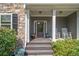 Cozy front porch with seating, potted plants, and a decorative door, offering a warm welcome at 27 Rose Brooke Cir, White, GA 30184