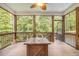 Relaxing screened porch with wooden floor, ceiling fan, comfortable seating, and natural light at 27 Rose Brooke Cir, White, GA 30184
