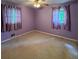 Comfortable bedroom with neutral carpeting, two windows with curtains, and a ceiling fan providing a relaxing and inviting ambiance at 7125 Chappell Cir, Atlanta, GA 30360