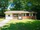 Charming single-story home with a brick facade, a well-maintained lawn, and mature trees creating a serene and inviting atmosphere at 7125 Chappell Cir, Atlanta, GA 30360
