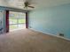 Bright living room featuring neutral carpet, a ceiling fan, and a large slider that provides ample natural light and outdoor views at 7125 Chappell Cir, Atlanta, GA 30360