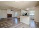 A bright living room flowing into the kitchen featuring a ceiling fan, fireplace, and hardwood floors at 1249 Scripps Sw Ct, Marietta, GA 30008